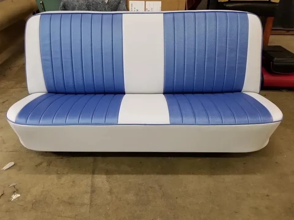 A blue and white couch is sitting on a concrete floor.