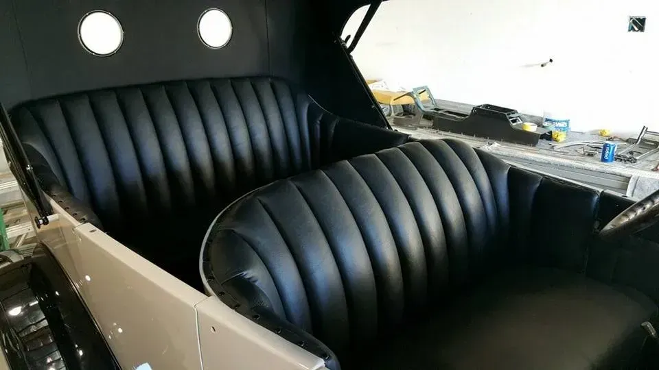 A close up of a black car seat in a garage.