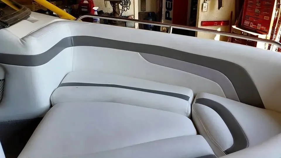 A white and gray boat is sitting in a garage.