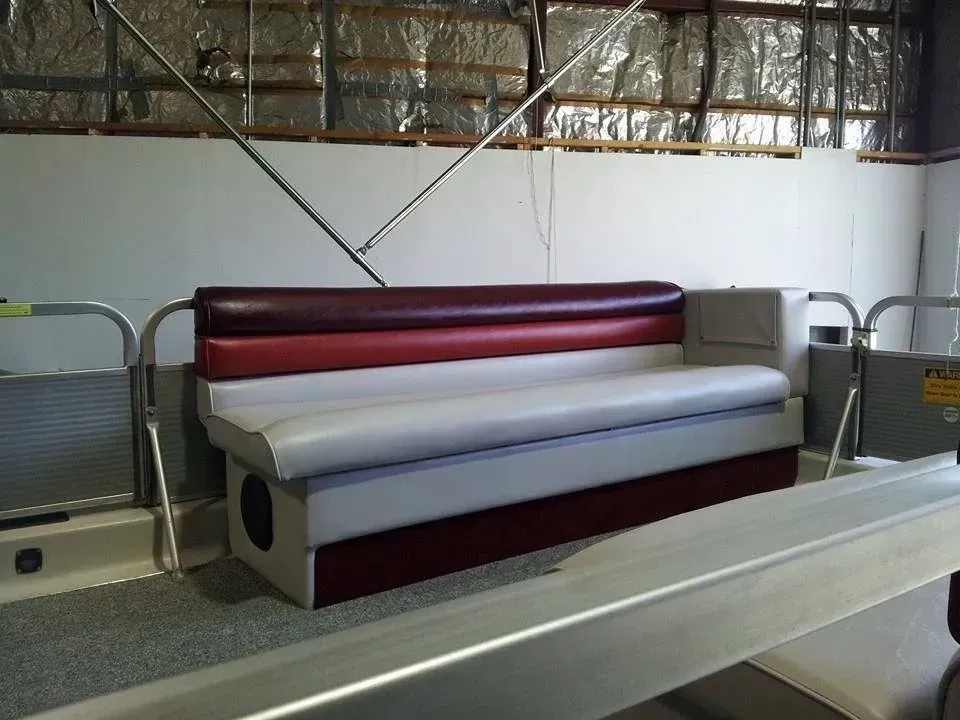 A red and white couch is sitting on a boat