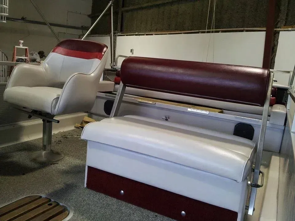 A chair and a bench are sitting on a boat