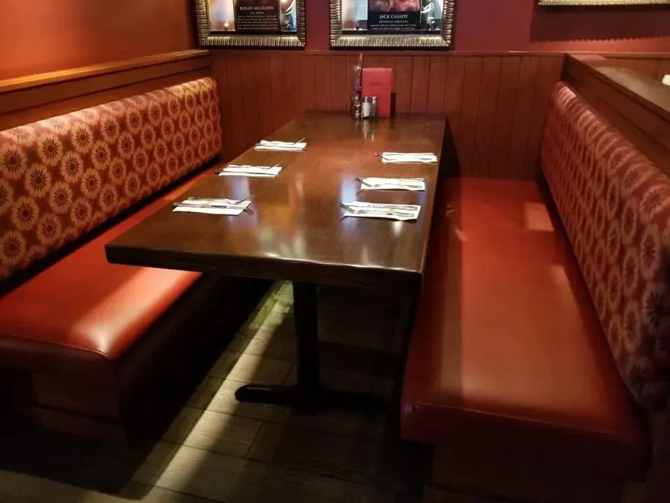 A restaurant booth with a table and utensils on it