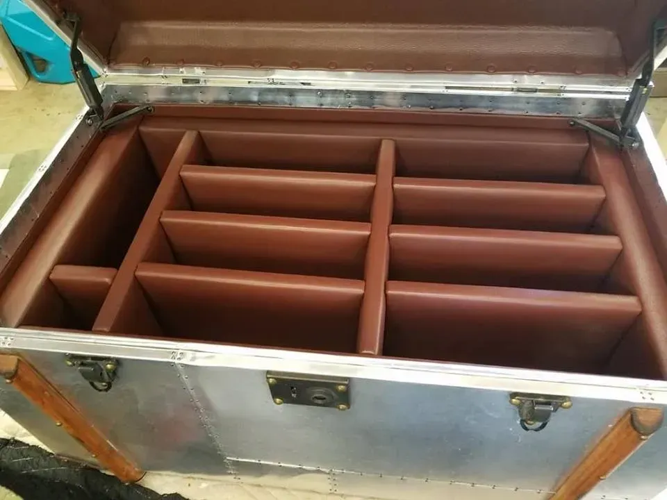 A silver trunk with brown dividers inside of it