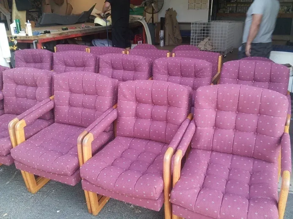A row of purple chairs with wooden arm rests