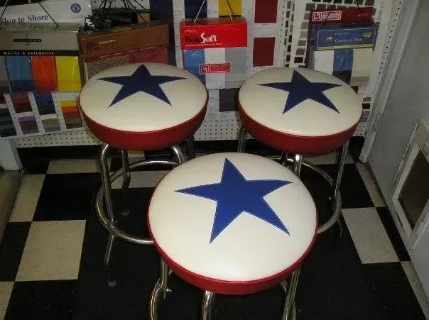 Three red white and blue bar stools with blue stars on them