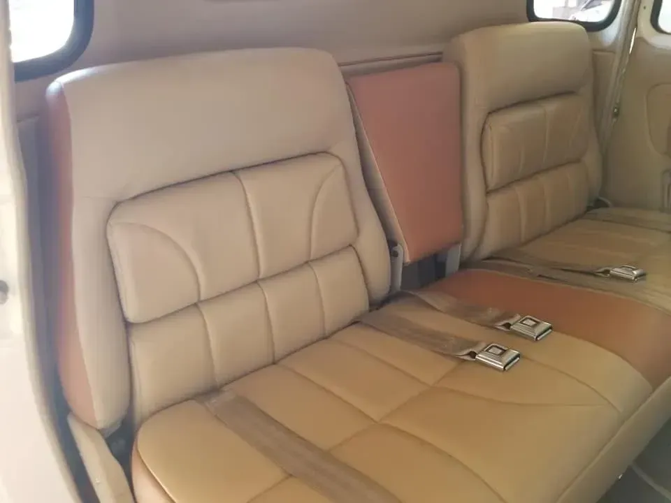 The back seat of a car with seat belts on it