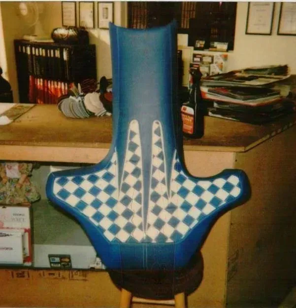 A blue and white checkered chair sits on a wooden stool