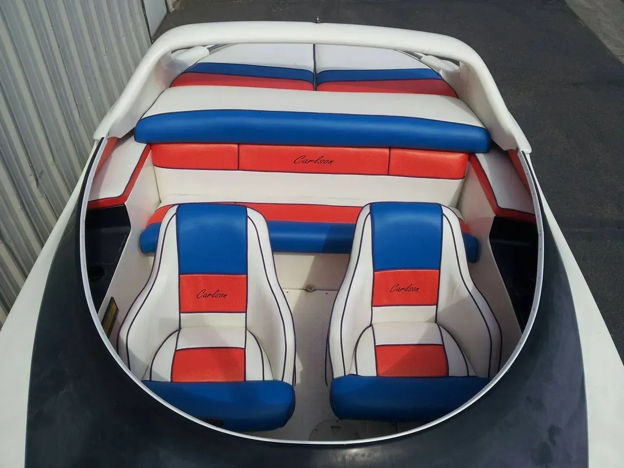 The inside of a boat with red white and blue seats