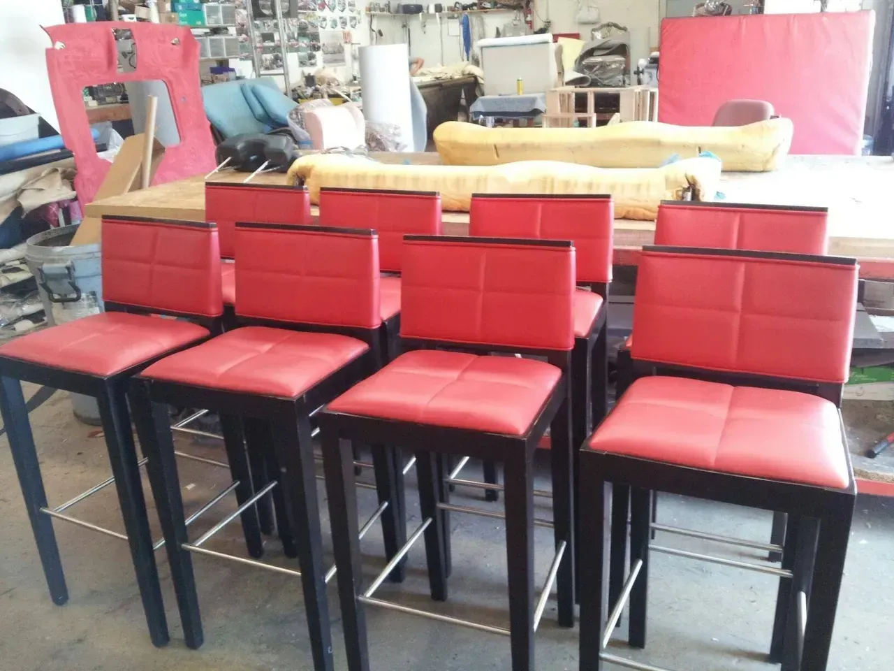 A row of red bar stools are lined up in a room