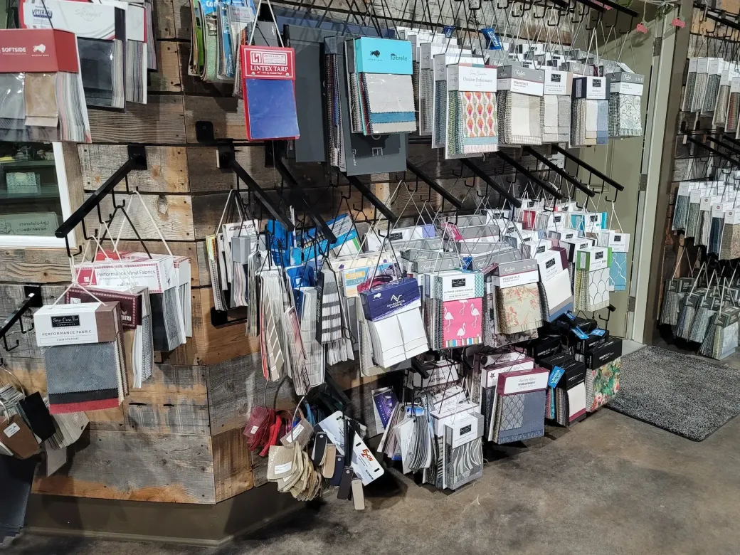 There are many different types of fabrics hanging on the wall.