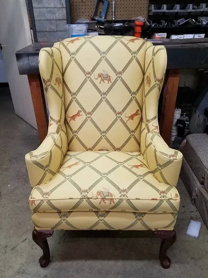 A yellow chair with a pattern of tigers on it