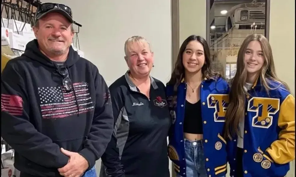 A group of people standing next to each other wearing varsity jackets.