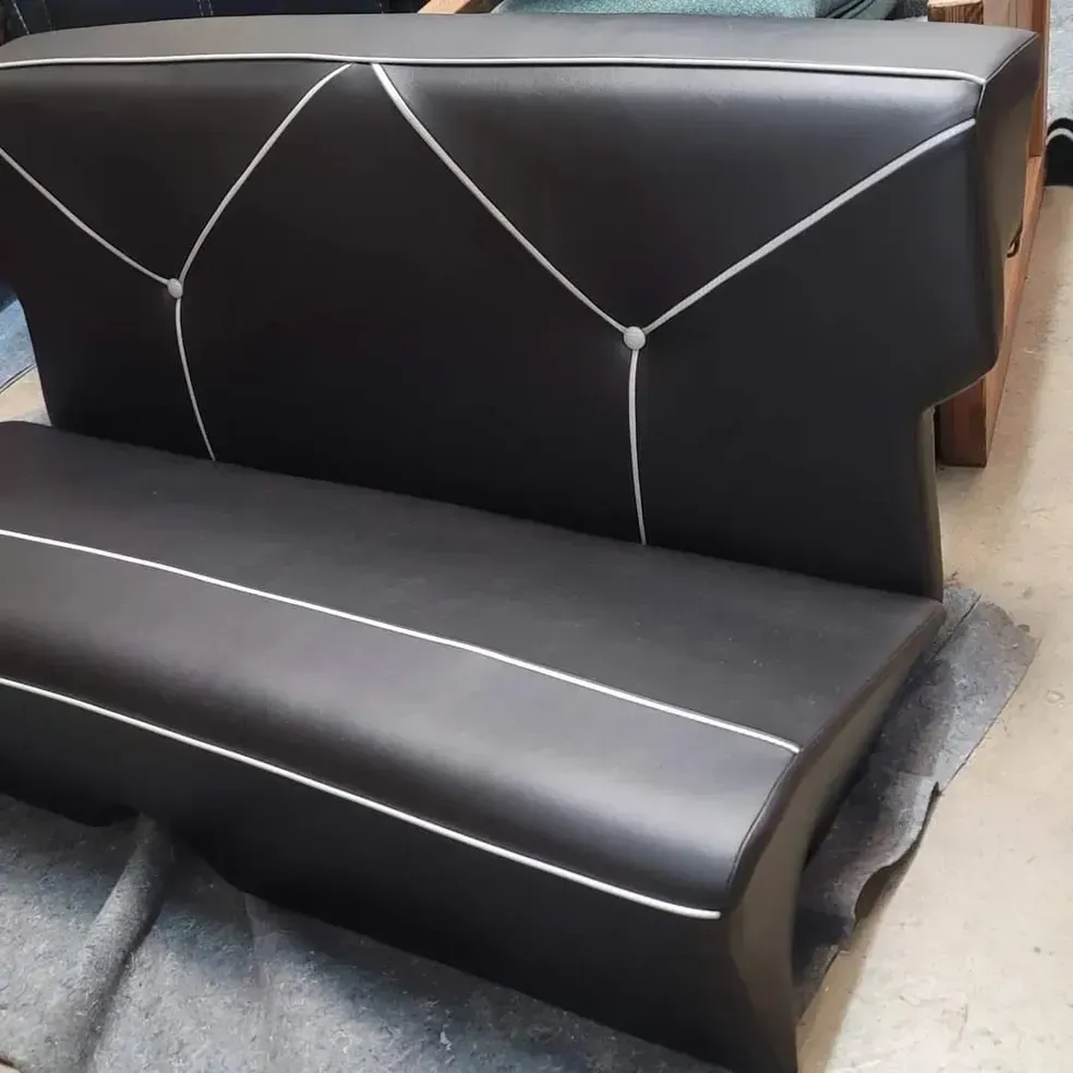 A black leather couch with white stripes on the back