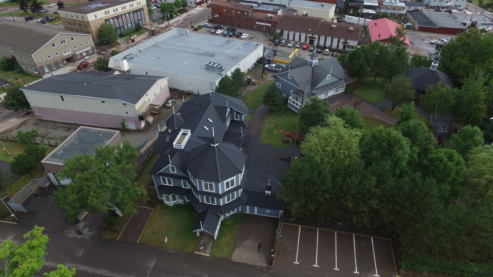 Aerial view of a town with buildings, including a unique, multi-story, round-shaped structure.