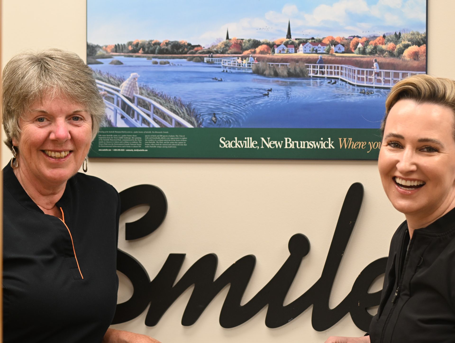 Two women smiling by a 