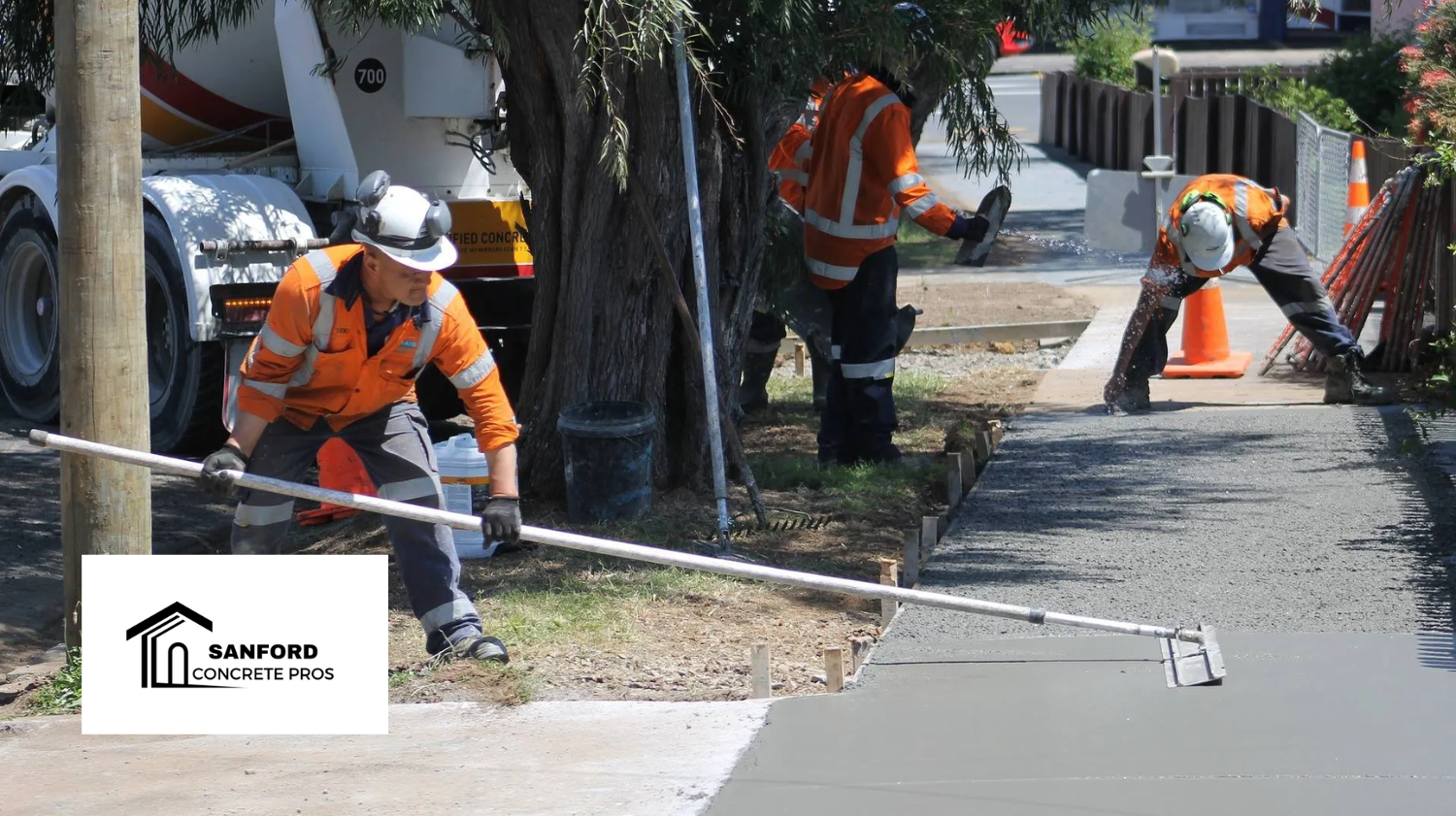 A group of construction workers are working on a sidewalk.