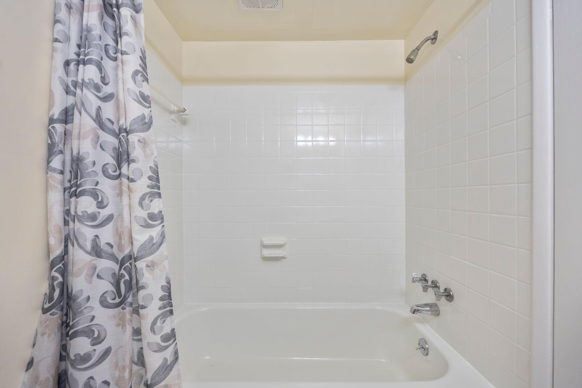 A bathroom with a bathtub , shower , and shower curtain.