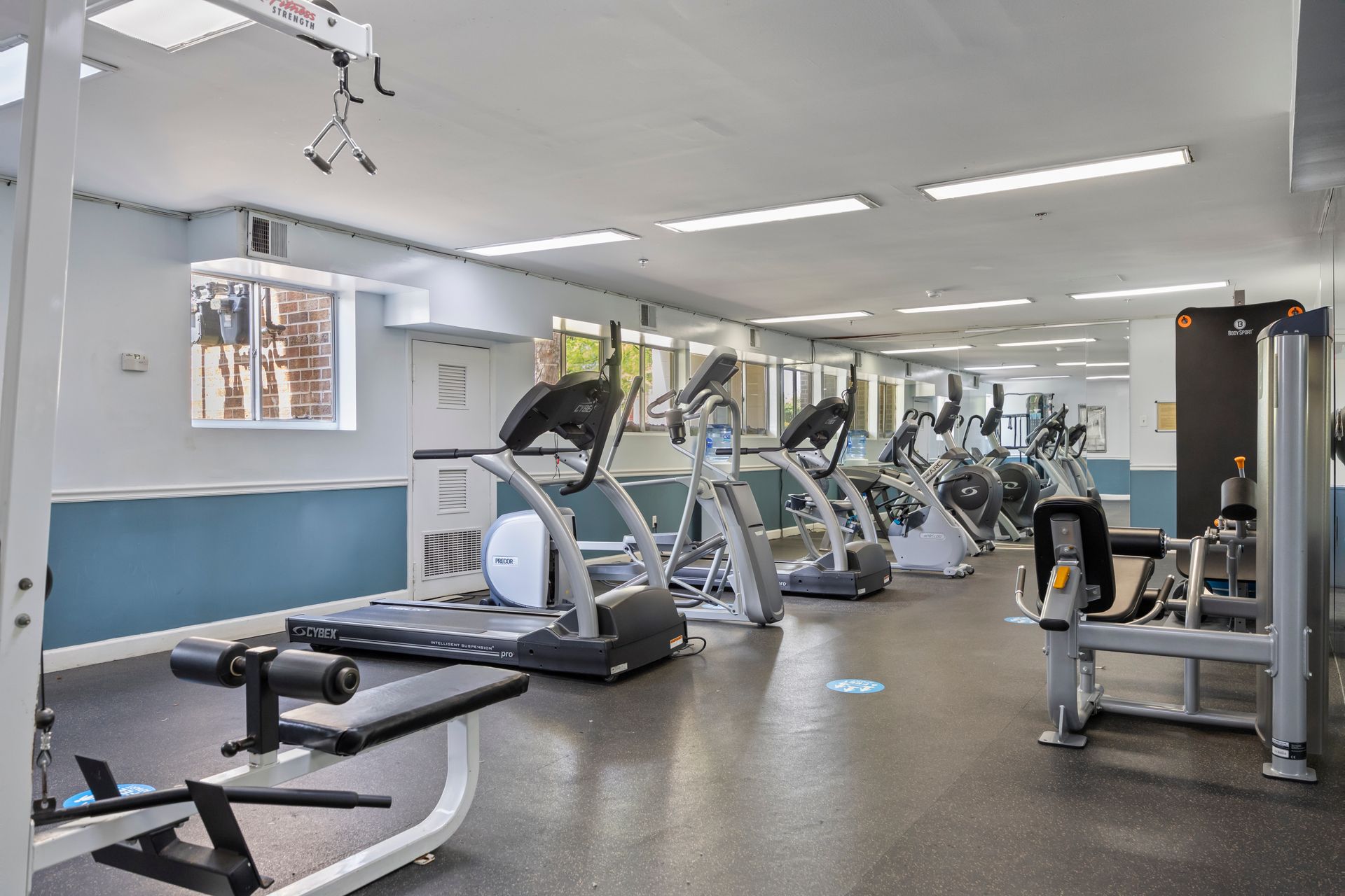 A large gym filled with lots of exercise equipment.