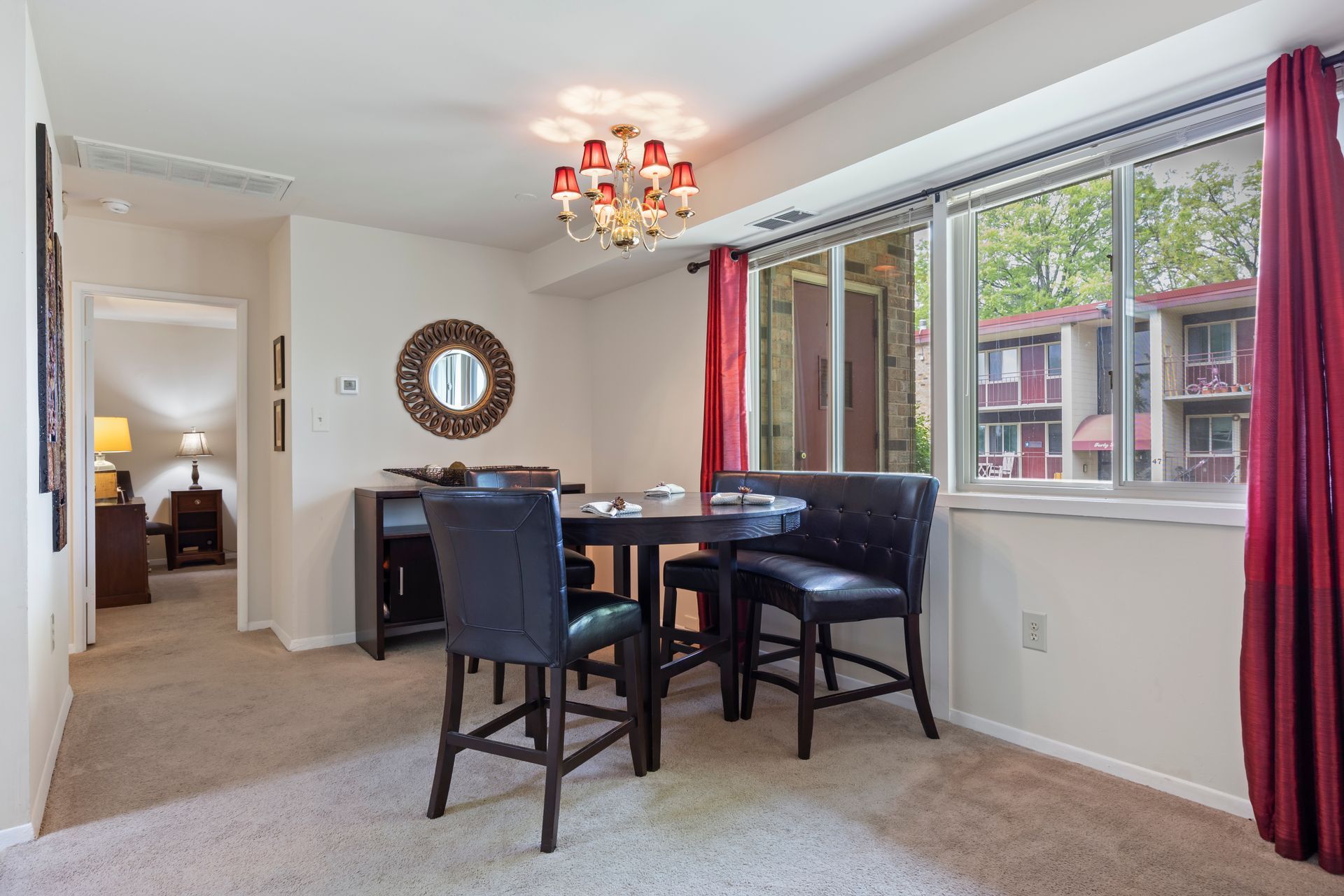 A dining room with a table and chairs and a large window.