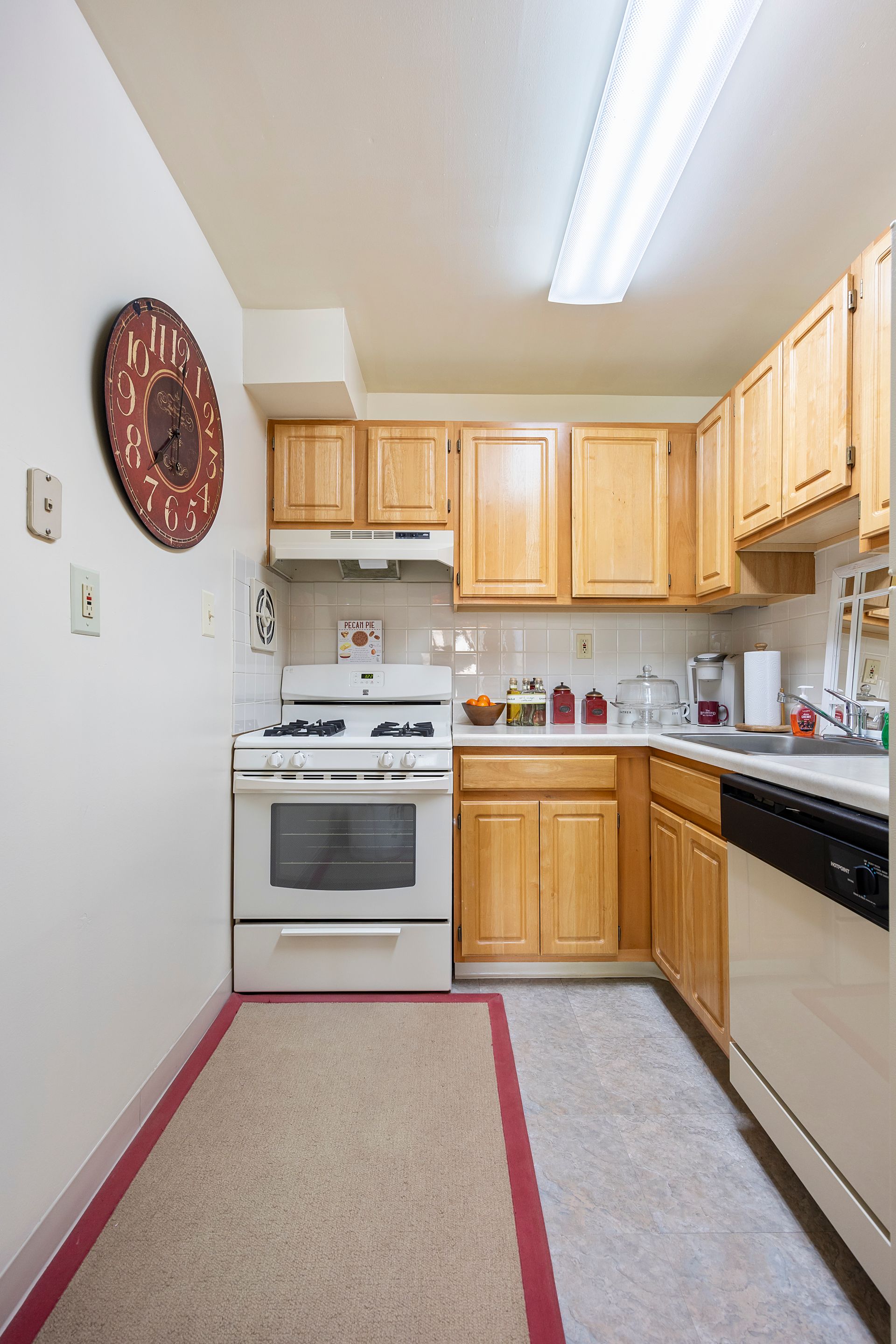 A kitchen with wooden cabinets and a white stove