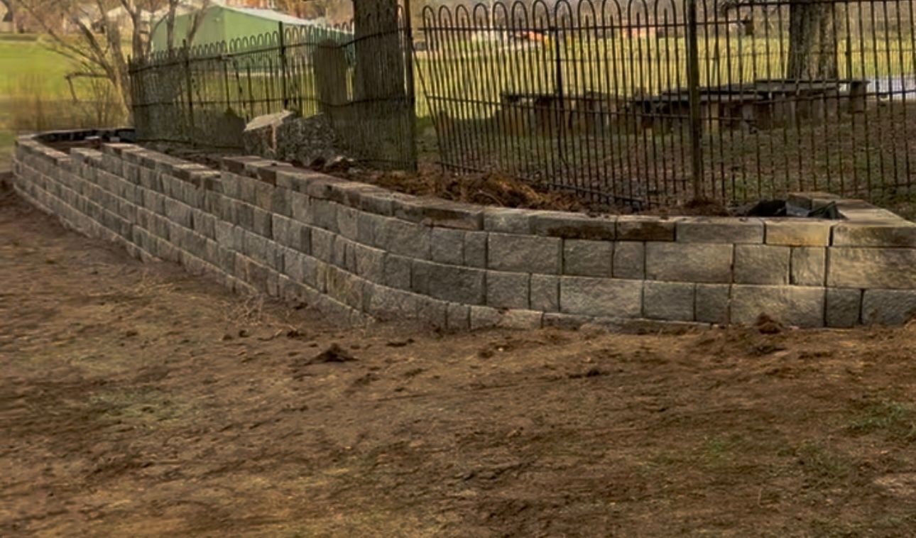 A brick wall is being built in front of a house.