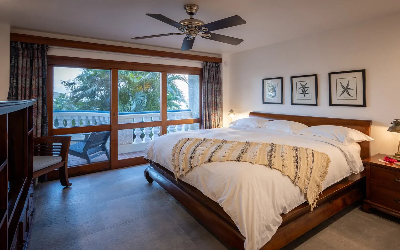 Bedroom with a large wooden bed, balcony access, and art on the wall.