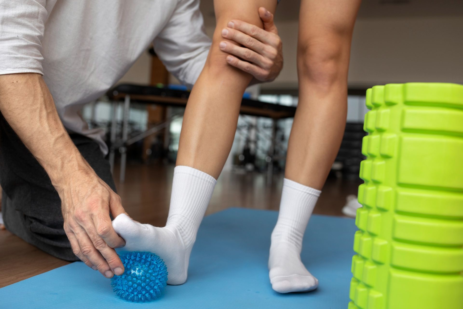 A man is putting a ball on a woman 's ankle.