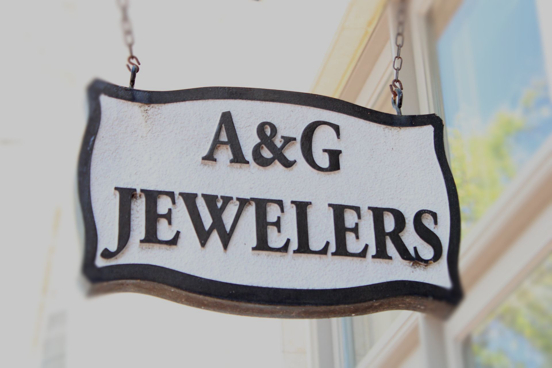 a sign for a & g jewelers hangs from a building