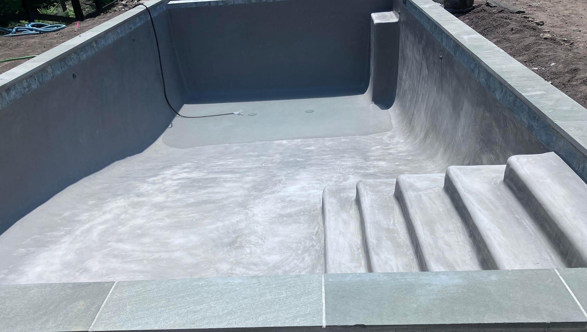 A concrete pool with stairs leading up to it