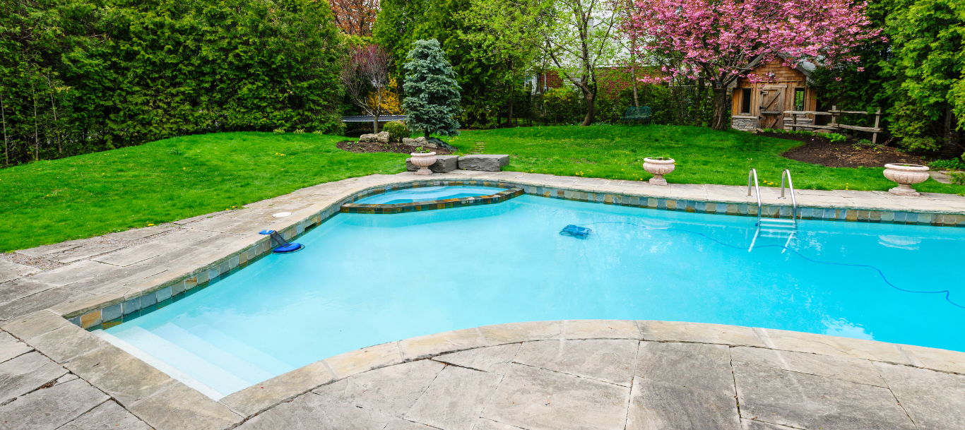 There is a large swimming pool in the backyard of a house.