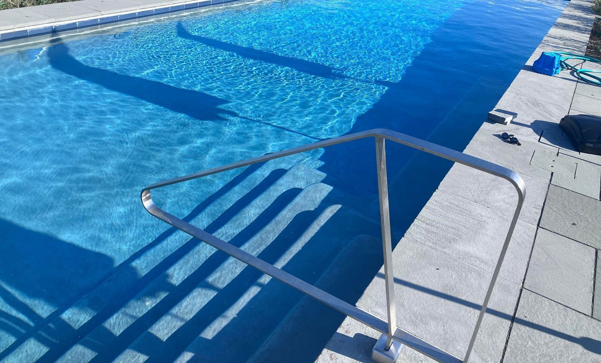 A swimming pool with a metal railing leading to it