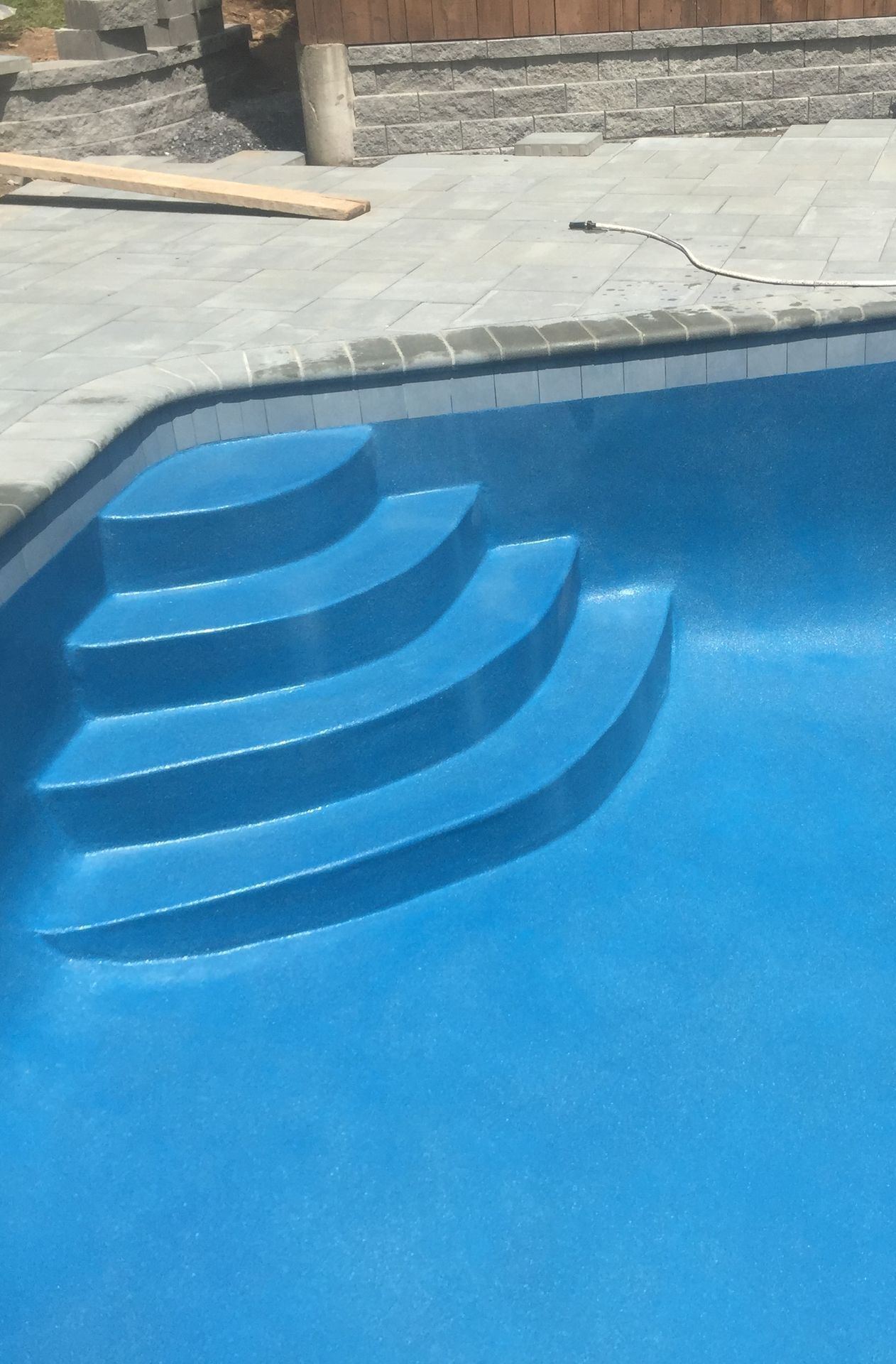 A blue swimming pool with stairs in it