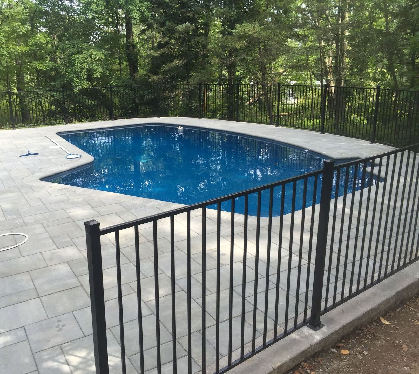 A large swimming pool with a black fence around it