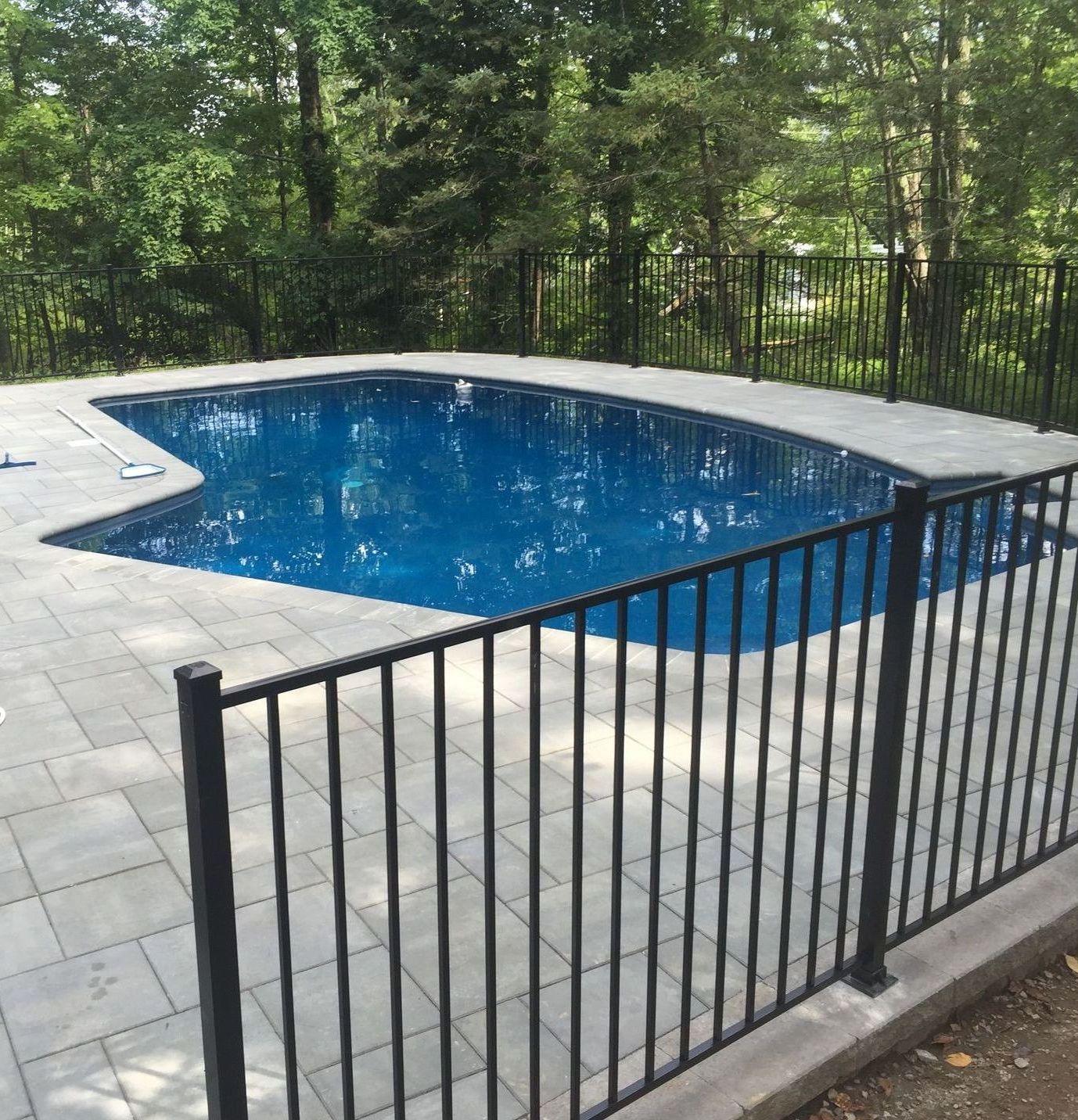 A large swimming pool with a black fence around it