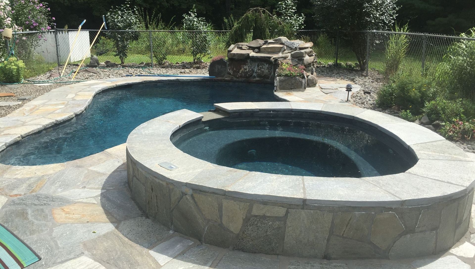 A swimming pool with a hot tub in the middle of it