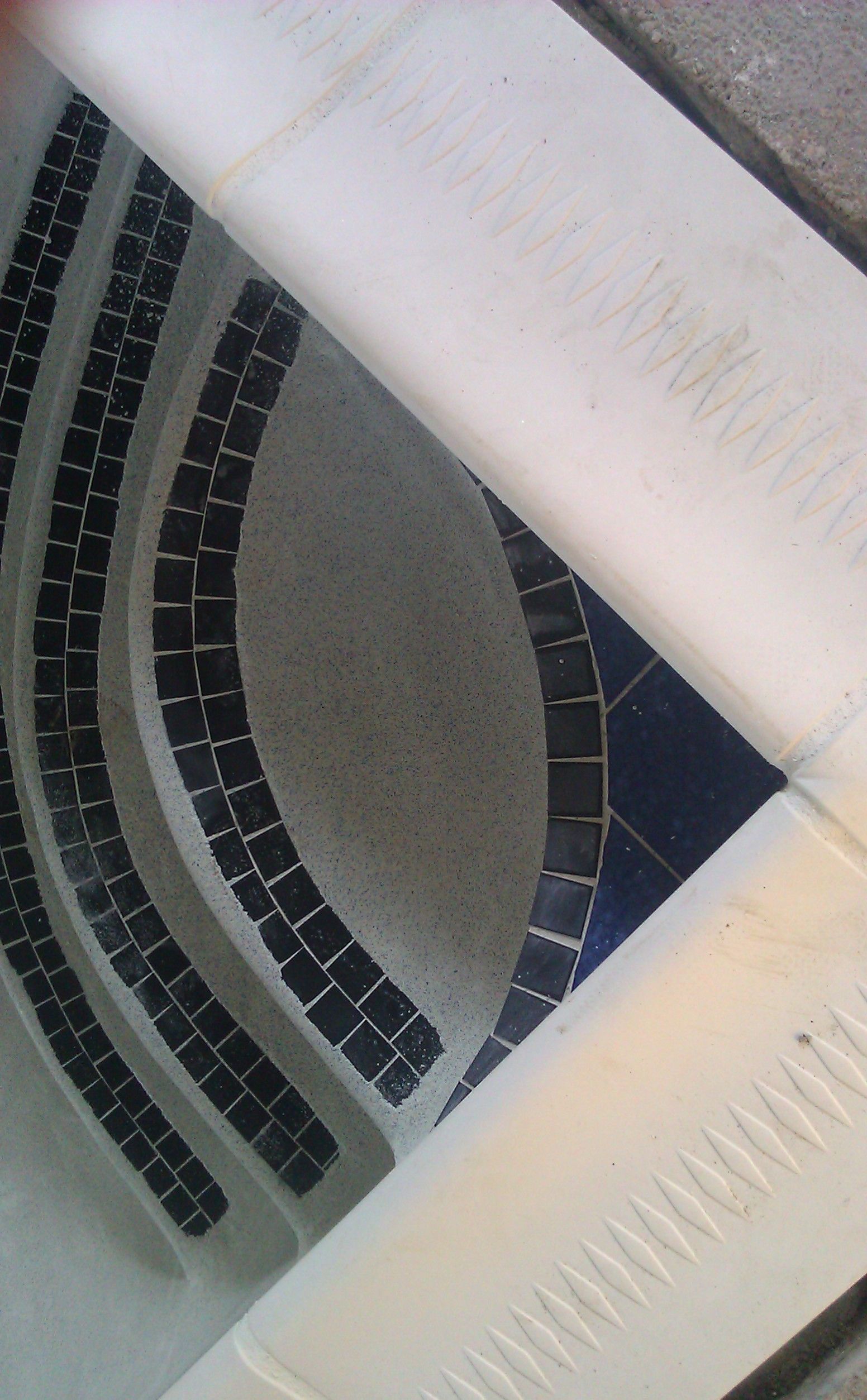 A close up of a swimming pool with black tiles