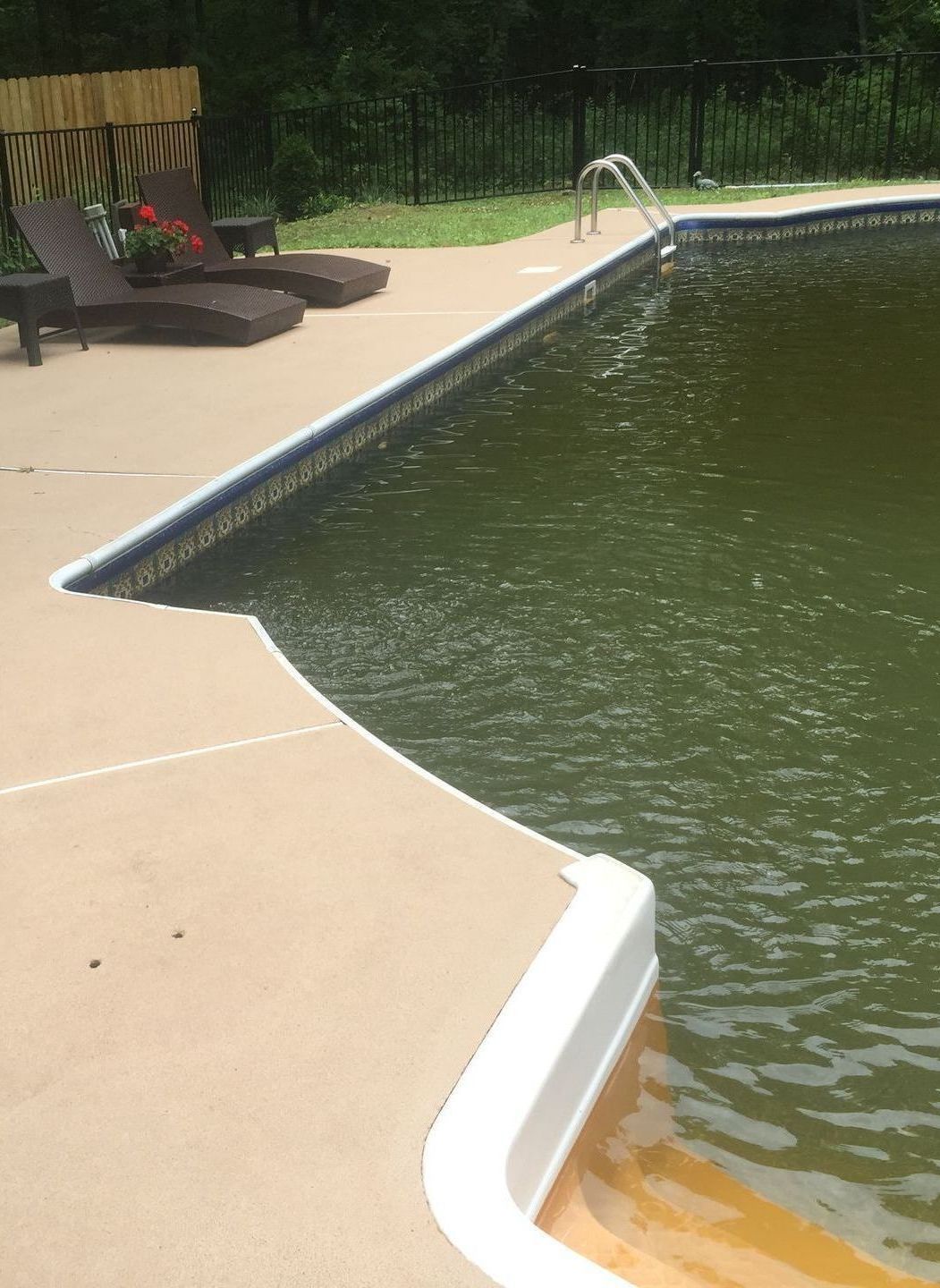 A swimming pool with chairs on the side of it
