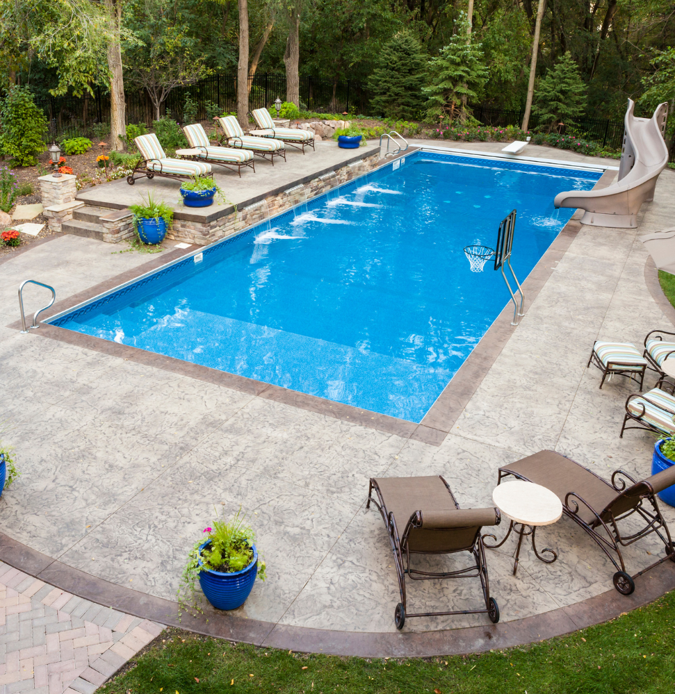A large swimming pool surrounded by chairs and plants