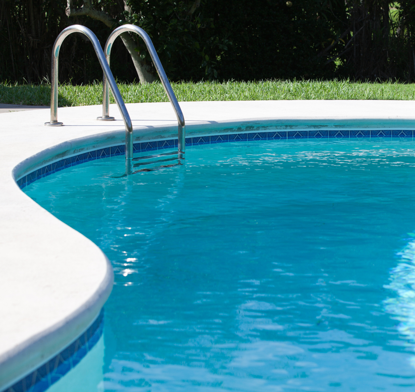 A large swimming pool with a gazebo in the background