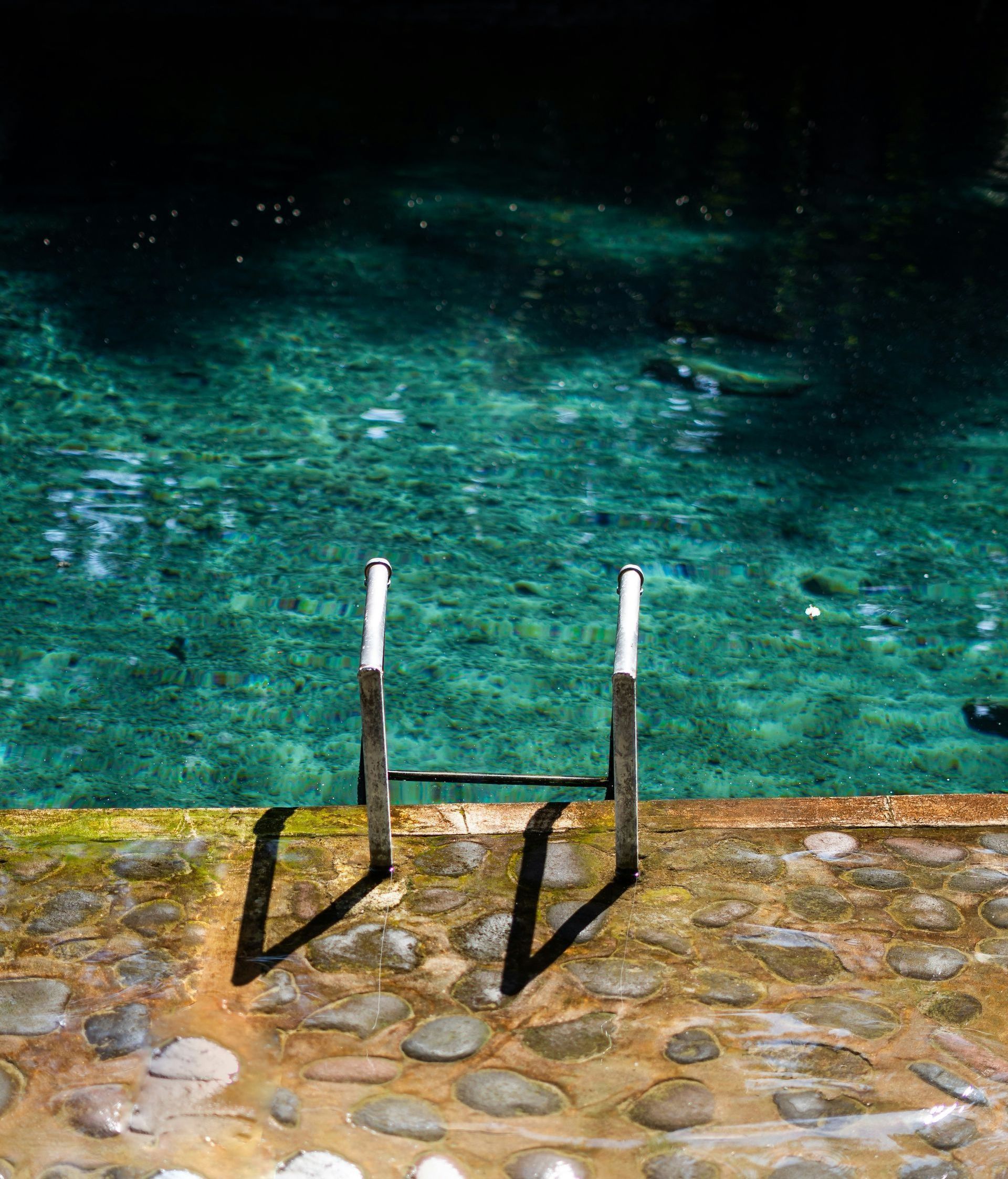 A pair of stairs leading into a swimming pool.