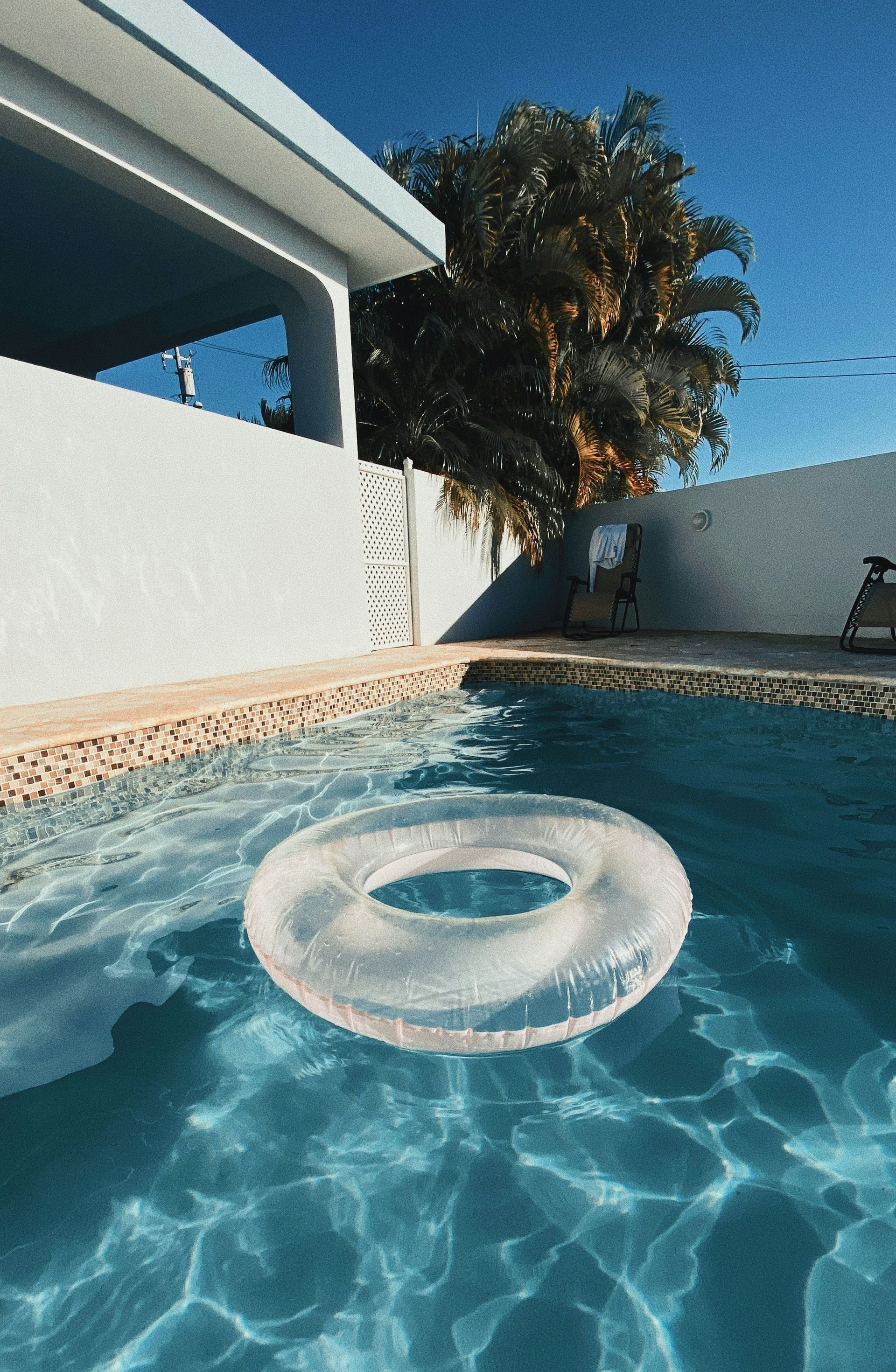 A clear inflatable ring is floating in a swimming pool.