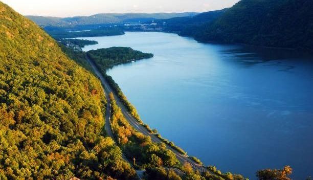 An aerial view of a lake surrounded by mountains and trees.