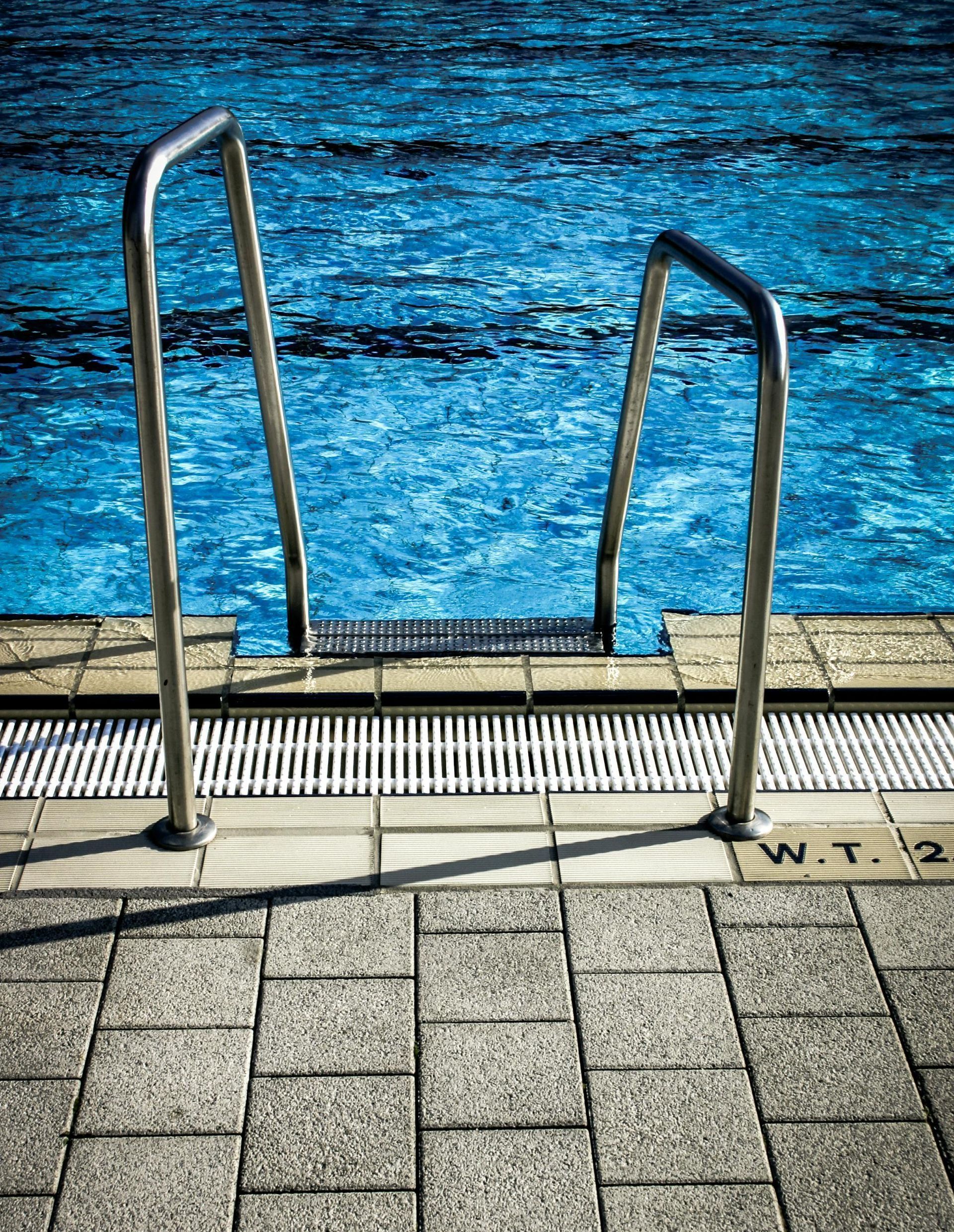 A staircase leading to a swimming pool with blue water.