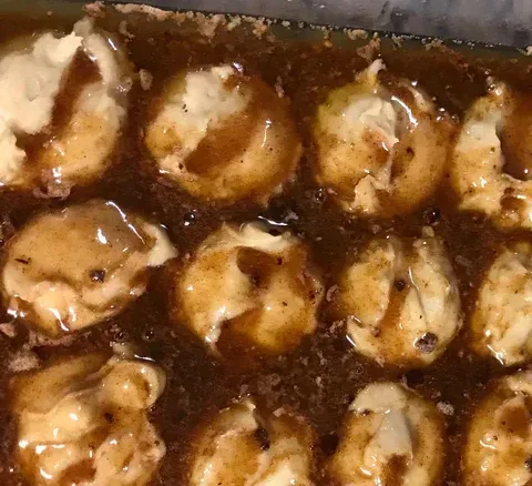 closeup of sourdough blobs with monkey bread sauce on top before it goes into the oven