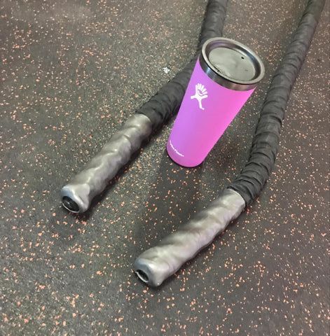 purple water bottle near battle ropes at the gym