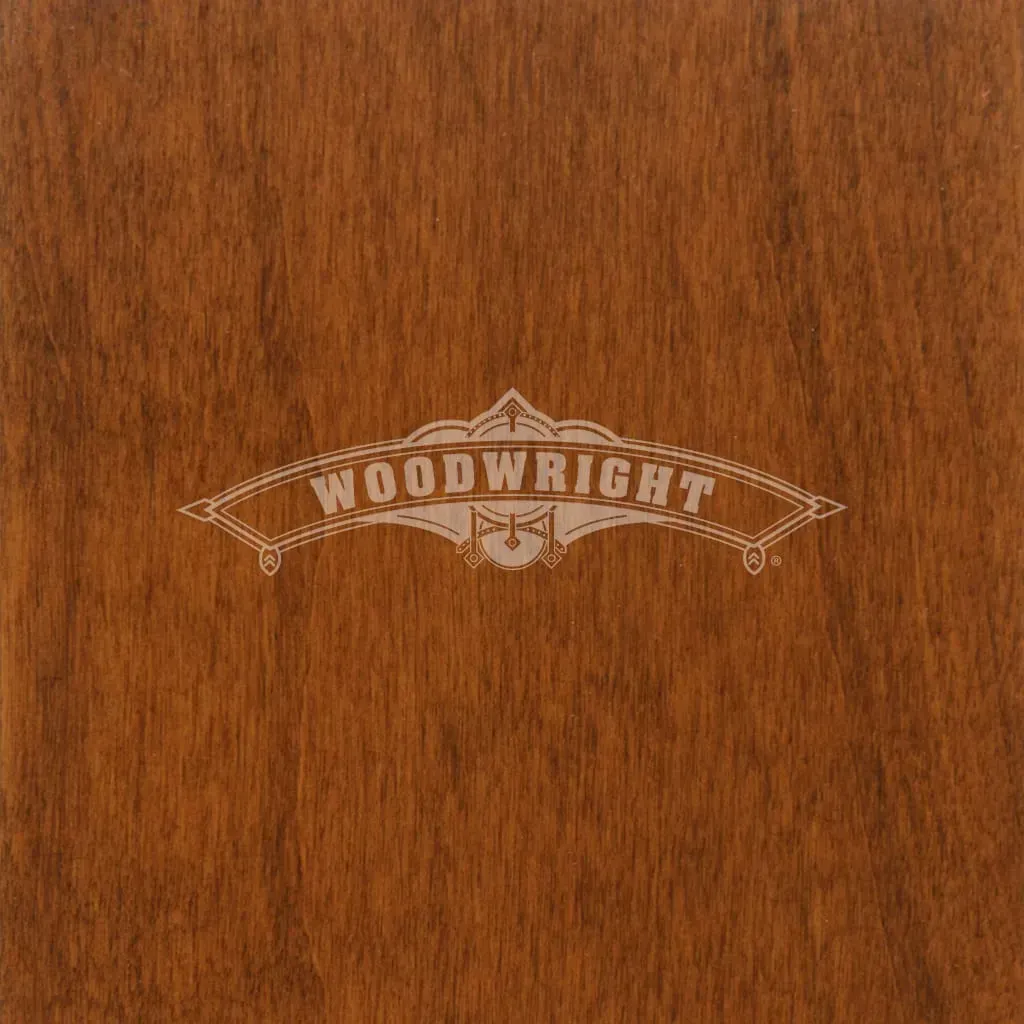 Woodwright logo etched in light color on a brown wood surface.