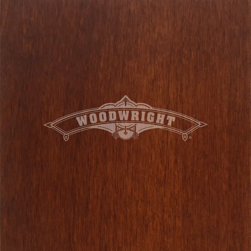 Woodwright logo etched in light color on a brown wood background.