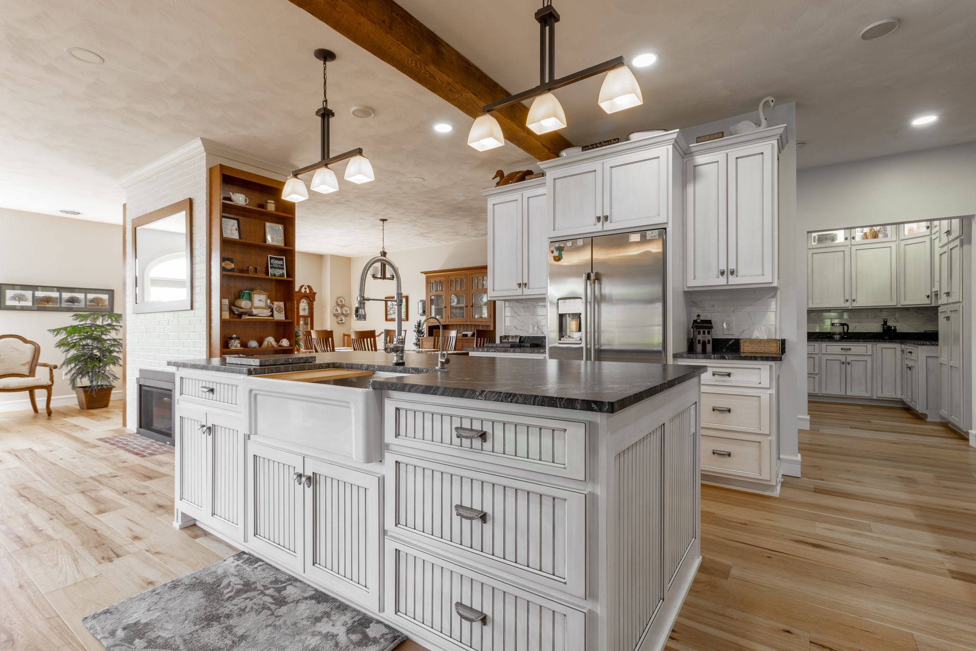 Open kitchen with white cabinets, island, and wood floors.
