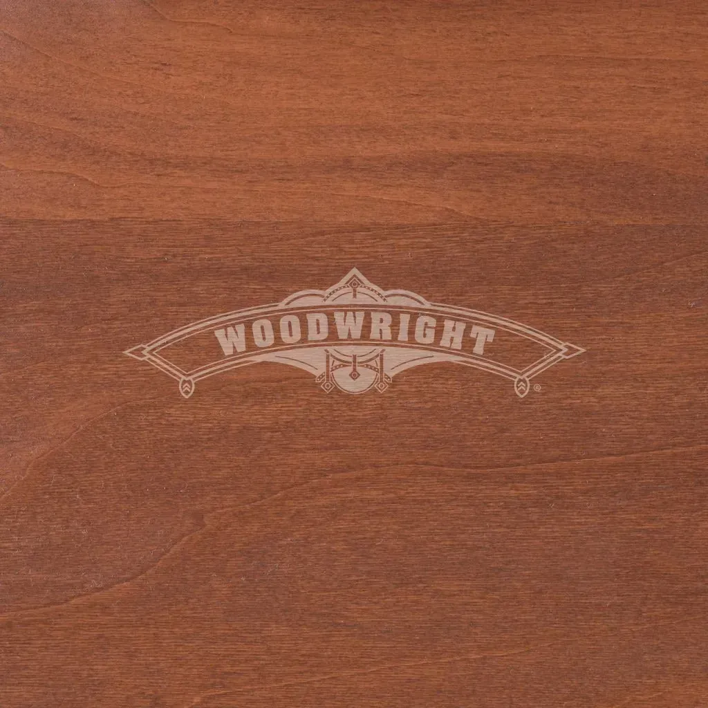 Woodwright logo on stained wood background, reddish-brown color.