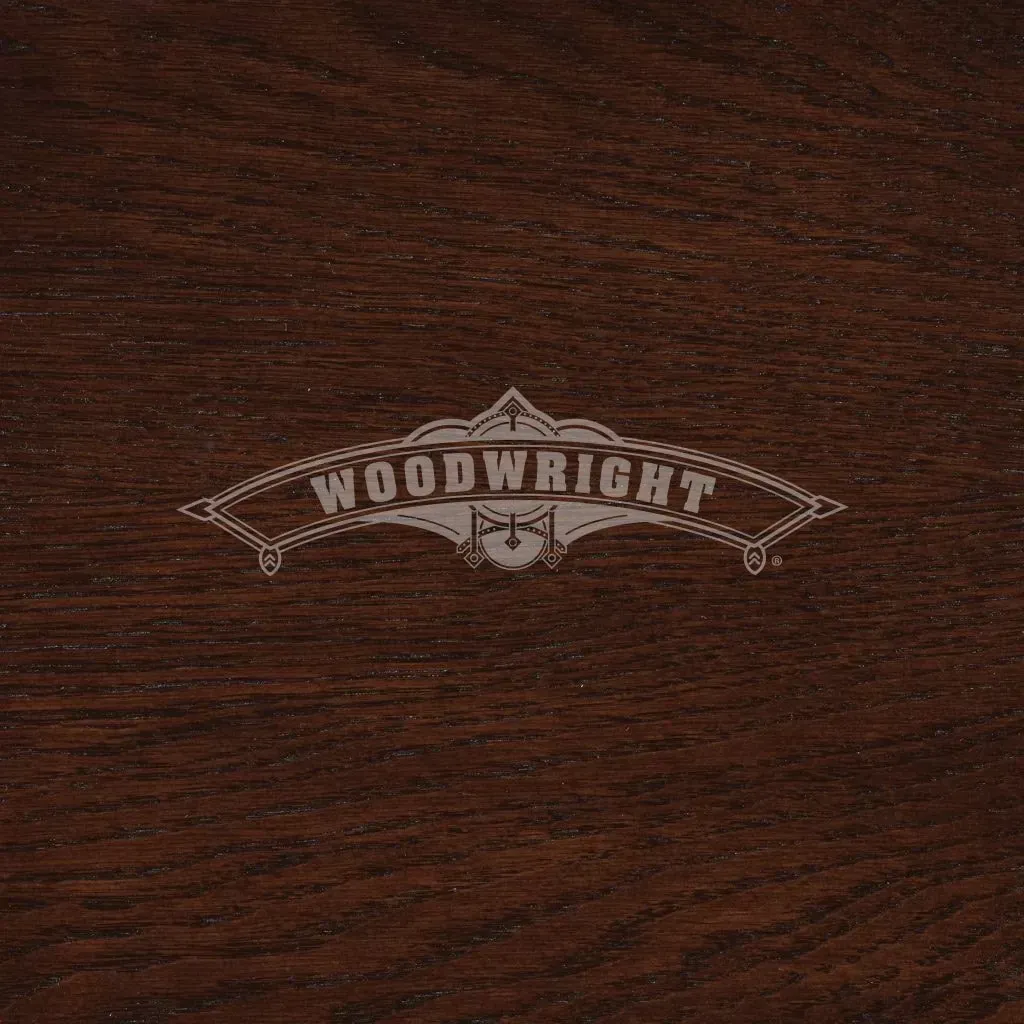 Woodwright logo etched in light color on a dark wood surface.
